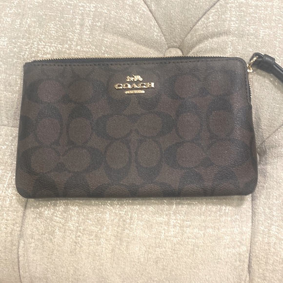 Wristlet‎ by coach this black and brown color is sized at 8 “ (L) x  5 “ …